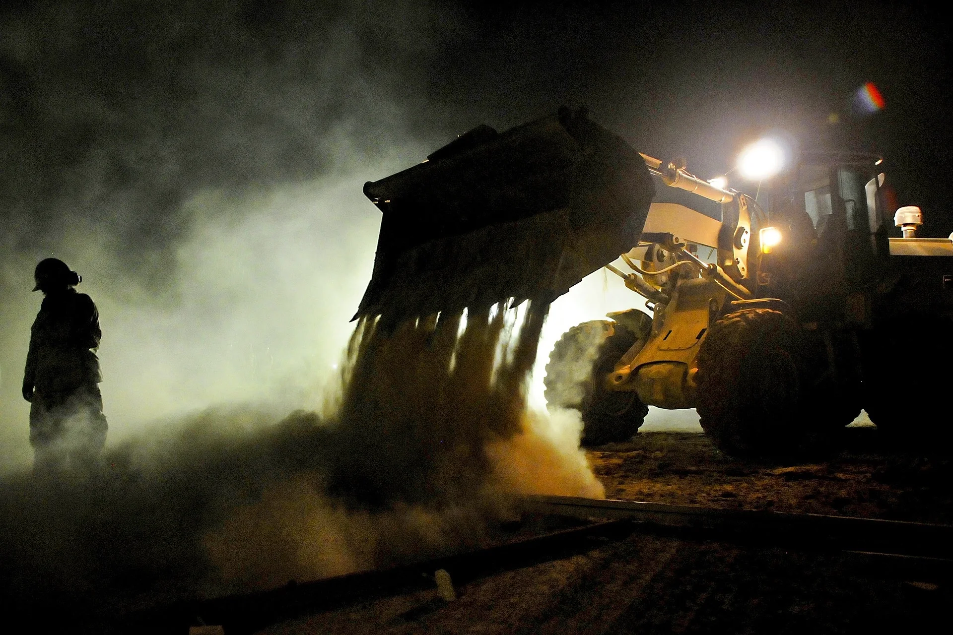 Heavy equipment and field personnel working at night